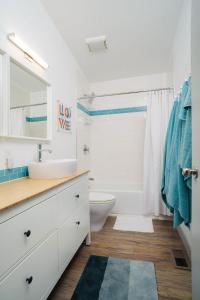 a white bathroom with a sink and a toilet at #StayinMyDistrict Modern Mid-Century Retreat in Beaverton