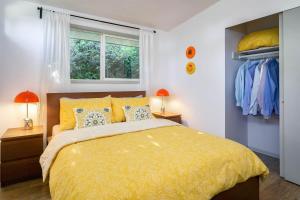 una camera da letto con un grande letto giallo con due lampade di #StayinMyDistrict Modern Mid-Century Retreat a Beaverton