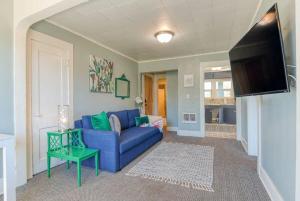 a living room with a blue couch and a tv at #StayinMyDistrict Heritage House Private Suite in Coos Bay