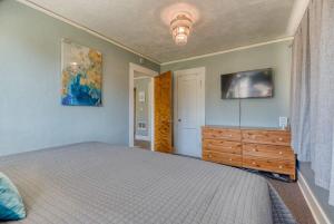 a bedroom with a bed and a dresser and a tv at #StayinMyDistrict Heritage House Private Suite in Coos Bay