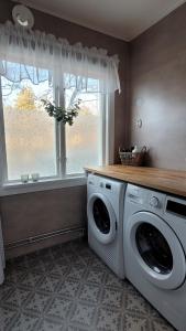 a laundry room with a washing machine and a window at Mysig stuga i Svärtinge in Svärtinge