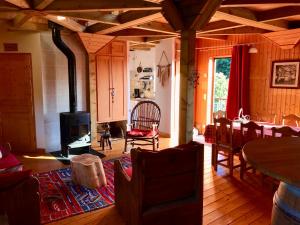 een woonkamer met een open haard en een tafel en stoelen bij Chalet avec bain nordique et sauna à Dabo in Dabo