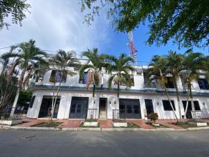 a white building with palm trees in front of it at Hotel Las Palmas in La Virginia