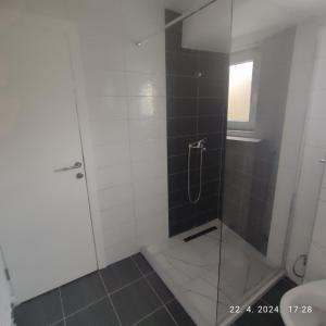 a bathroom with a glass shower with a toilet at Apartman Numero Uno in Vogošća