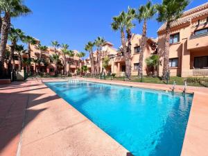 una piscina di fronte a un edificio con palme di Modern 2 Bedroom Beachside Apartment NR72 a Los Alcázares