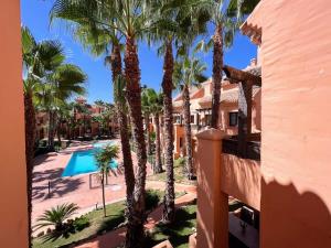 una vista dal balcone di un resort con palme di Modern 2 Bedroom Beachside Apartment NR72 a Los Alcázares