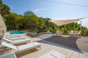 patio con sedie, piscina e baldacchino di Villa Mambrini a Sorrento