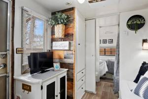 ein Wohnzimmer mit einem TV und ein Schlafzimmer in der Unterkunft #StayinMyDistrict Twin Falls Backyard Glamper in Twin Falls
