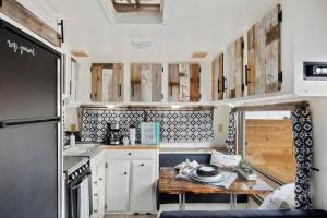 a kitchen with white cabinets and a wooden table at #StayinMyDistrict Twin Falls Backyard Glamper in Twin Falls