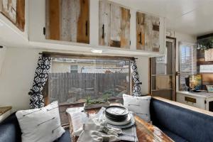 - un salon avec un canapé bleu et une fenêtre dans l'établissement #StayinMyDistrict Twin Falls Backyard Glamper, à Twin Falls