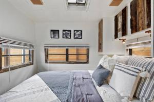 1 dormitorio con 1 cama grande y 2 ventanas en #StayinMyDistrict Twin Falls Backyard Glamper, en Twin Falls