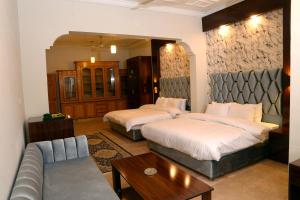 une chambre d'hôtel avec deux lits et un canapé dans l'établissement Royal Continental, à Islamabad