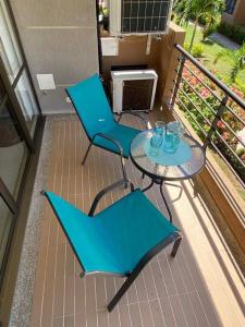 um pátio com 2 cadeiras e uma mesa na varanda em Hermoso Apto en Ricaurte con piscina em Ricaurte