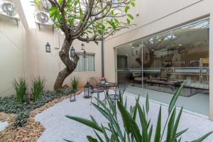 a courtyard with a tree and a table and chairs at Faro Norte Suites in Asuncion