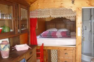 a bedroom with a bed in a wooden cabin at Les Roulottes du Petit Brimeux in Brimeux