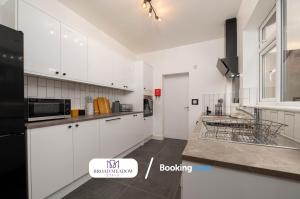 a kitchen with white cabinets and a black refrigerator at Heart of City, 3 Bed House By Broad Meadow Stays Short Lets and Serviced Accommodation Lincoln With Free Wi-Fi in Lincolnshire