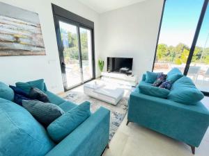 uma sala de estar com dois sofás azuis e uma lareira em Modern 4 Bed Villa with Pool LC4 em Orihuela