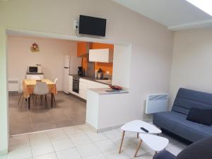a living room with a blue couch and a kitchen at le Gaspalette in Saint-Uze