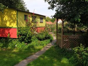 a garden with a colorful house and a path at Les Roulottes du Petit Brimeux in Brimeux
