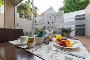 a breakfast table with fruit and coffee on a balcony at Faro Norte Suites in Asuncion