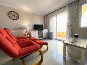 un soggiorno con divano rosso e TV di Pleasant 4 Bedroom Townhouse with Com Pool VM7 a Orihuela