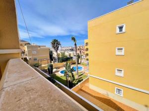 una vista dal balcone di un edificio giallo di Pleasant 4 Bedroom Townhouse with Com Pool VM7 a Orihuela