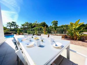 uma mesa branca com tigelas brancas e lavatórios num pátio em Modern 4 Bed Villa with Pool LC4 em Orihuela