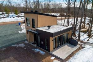 una piccola casa nel bosco con la neve sul terreno di Chalet Élios a Brownsburg