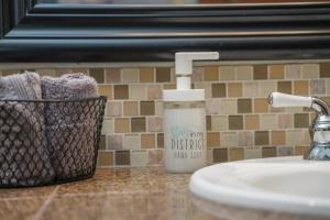 a bottle of soap next to a bathroom sink at #StayinMyDistrict Pendelton Place Walk to Mt Tabor in Portland +24 photos