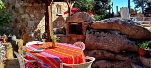 a table and chairs with a table and a stone oven at La Bergerie de Pauline - Bord de mer, vue unique in Pianottoli-Caldarello