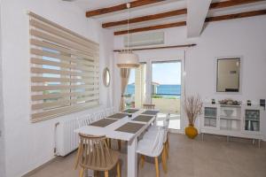 a white dining room with a table and chairs at Beachside luxury apartment in Kómi