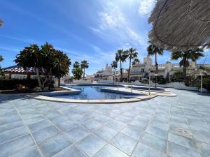 basen z palmami i budynkami w obiekcie Botanical 2 Bedroom Bungalow with Com Pool VM33 w mieście Orihuela