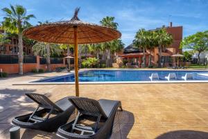 para krzeseł pod parasolem obok basenu w obiekcie Modern 2 Bed Apartment with Com pool VM31 w mieście Orihuela