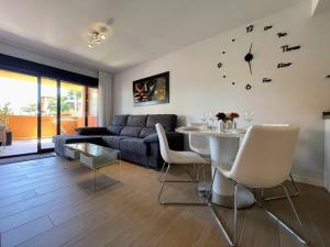 salon z kanapą, stołem i zegarem w obiekcie Modern 2 Bed Apartment with Com pool VM31 w mieście Orihuela