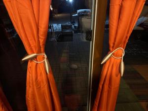 um par de cortinas laranja em frente a um espelho em Jays Ranch Hamden em Hamden
