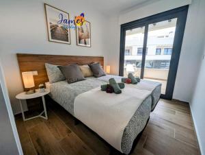un dormitorio con una cama con dos animales de peluche en Penthouse with Com Pool Villamartin Golf VM36, en San Miguel de Salinas