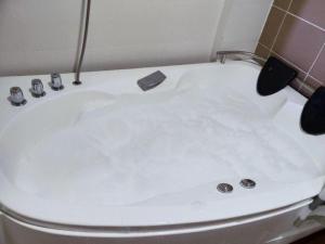 a white bath tub in a bathroom at MySuite Studio Apartment Melaka Waterpark Resort in Ayer Keroh