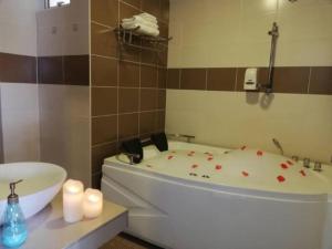 ein Badezimmer mit einer Badewanne, einem WC und Kerzen in der Unterkunft MySuite Studio Apartment Melaka Waterpark Resort in Ayer Keroh