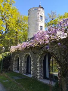 una torre con fiori viola in cima a un edificio di Chambres d'hôtes La Tour de Bellevue a Saumur