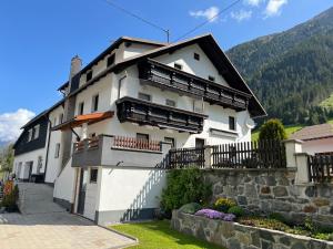 ein weißes Gebäude mit Balkon auf der Seite in der Unterkunft Ferienwohnung Annamaria und Manuel Melmer in Sankt Leonhard im Pitztal