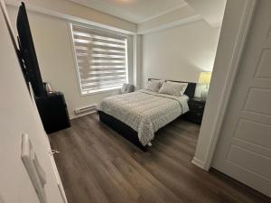 1 dormitorio con cama y ventana en Keppel Circle Residence, en Brampton