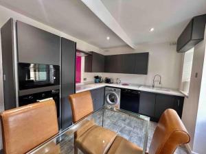 a kitchen with a glass table and chairs in it at The Haven by MaisonPro in Gloucestershire