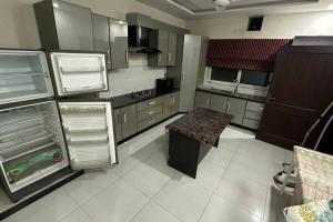 a kitchen with stainless steel cabinets and a bench in it at Jays Guest House. in Islamabad