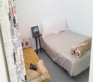 a small bedroom with a bed and a laptop on a table at Studio near the sea for surfing lovers welcome in Safi
