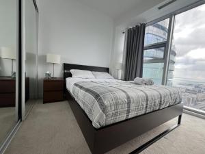 a bedroom with a bed and a large window at Prime Stay Suites in Toronto