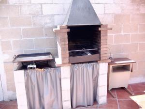 een bakstenen oven met een grill in een kamer bij 3 bedrooms house with private pool enclosed garden and wifi at Chatun in Chatún