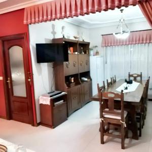een eetkamer met een tafel en een televisie bij 3 bedrooms house with private pool enclosed garden and wifi at Chatun in Chatún