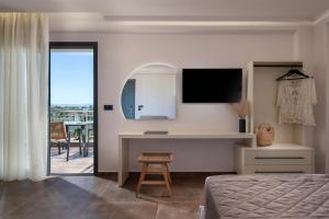 una camera da letto con un letto e una scrivania con una televisione di NATURE VIEW a Sárti