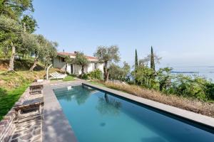 a swimming pool in front of a house at Villa Artista in Gardone Riviera