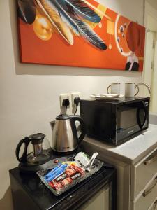 een magnetron op een fornuis in een keuken bij Cozy one bedroom apartment in Riyad